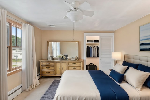 bedroom featuring baseboard heating, a closet, light colored carpet, and ceiling fan