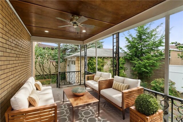 sunroom with plenty of natural light, wooden ceiling, and ceiling fan