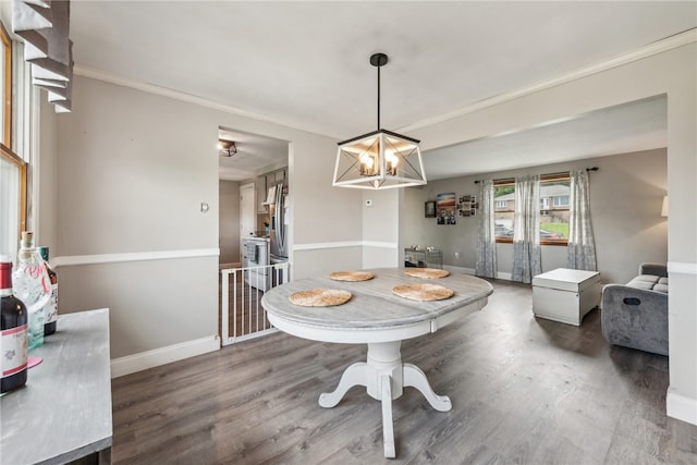 dining space with an inviting chandelier, crown molding, and hardwood / wood-style floors