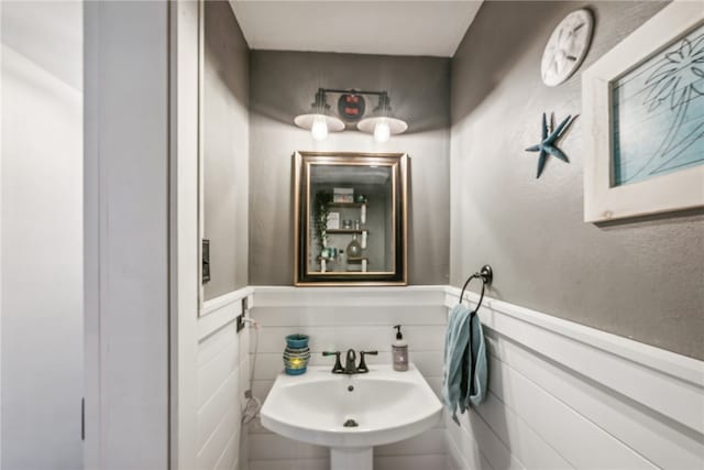 bathroom with sink and tile walls