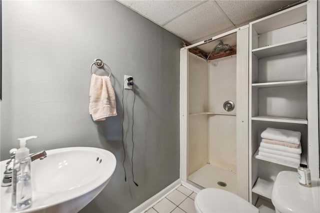 bathroom featuring walk in shower, sink, a paneled ceiling, toilet, and tile patterned flooring