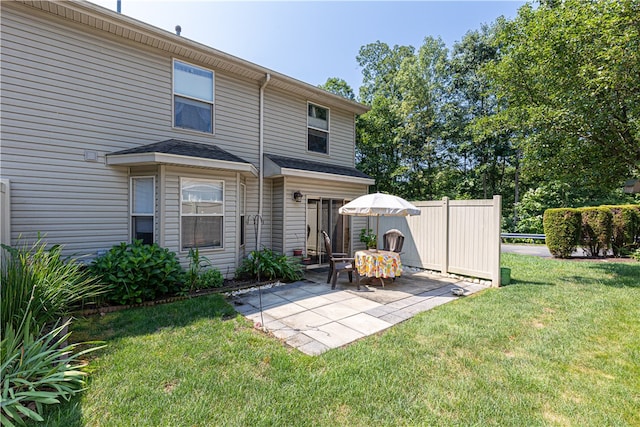 back of property featuring a patio area and a lawn