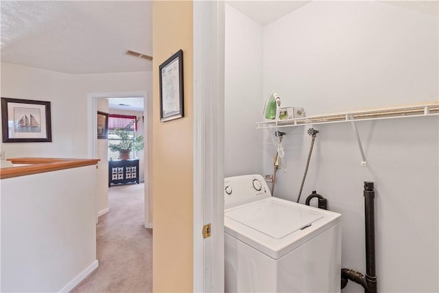 washroom featuring baseboards, washer / clothes dryer, visible vents, and light colored carpet