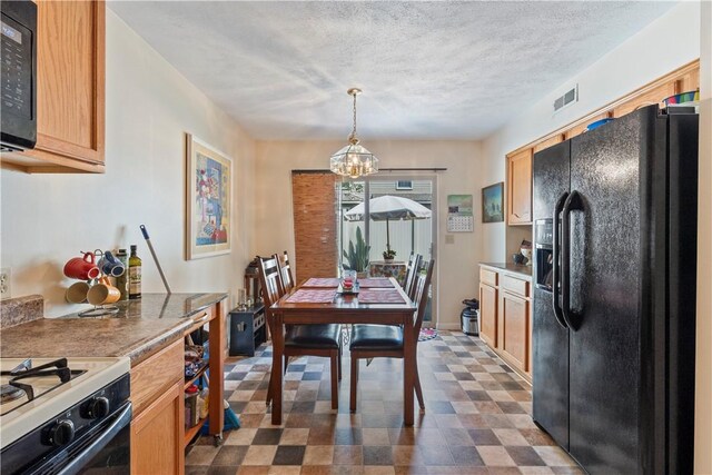 dining space featuring a notable chandelier, a textured ceiling, and dark tile patterned flooring