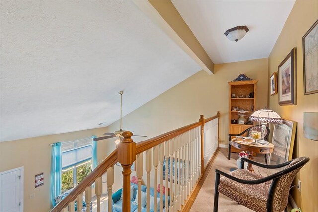 hallway featuring lofted ceiling with beams and light carpet