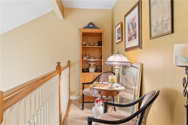 living area with vaulted ceiling with beams, baseboards, an upstairs landing, and light colored carpet