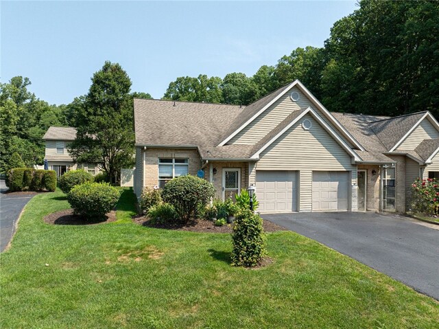 ranch-style home featuring a garage and a front yard