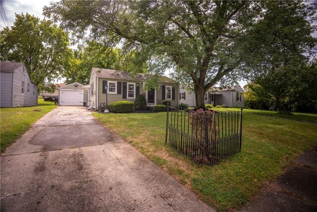 ranch-style home with a garage, an outbuilding, and a front lawn