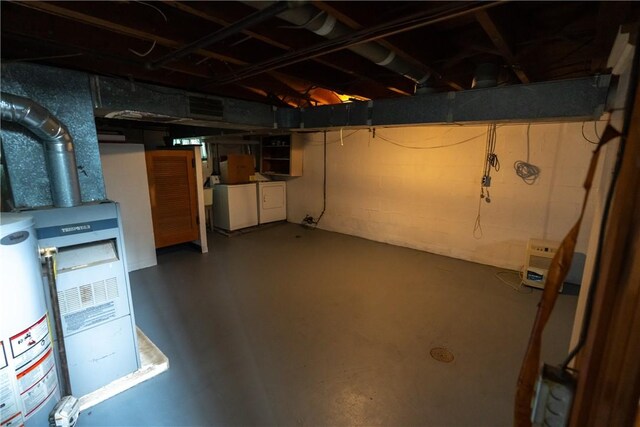 basement with water heater and independent washer and dryer