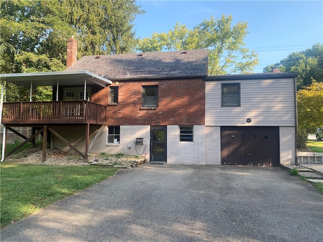 exterior space with a front lawn, a garage, and a deck