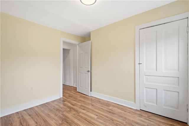 unfurnished bedroom with light hardwood / wood-style flooring and a closet