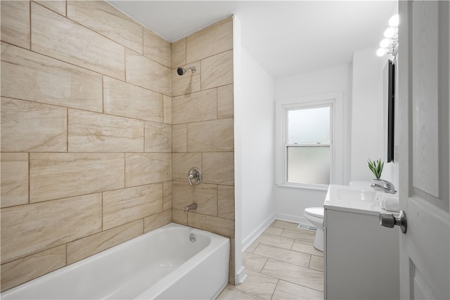 full bathroom featuring tiled shower / bath, vanity, toilet, and tile patterned floors