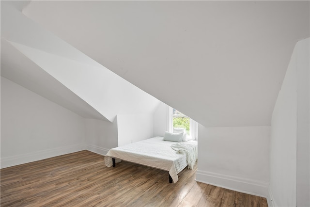 additional living space with vaulted ceiling and dark wood-type flooring