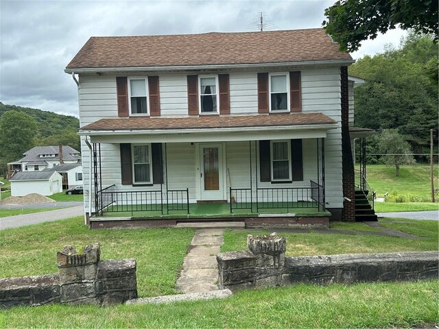 view of front of home with covered porch and a front yard