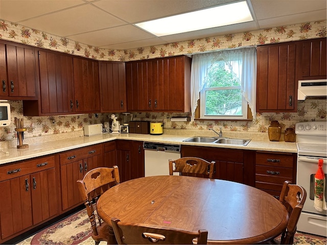 kitchen with white appliances, a drop ceiling, and sink