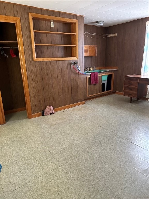 unfurnished living room featuring wooden walls