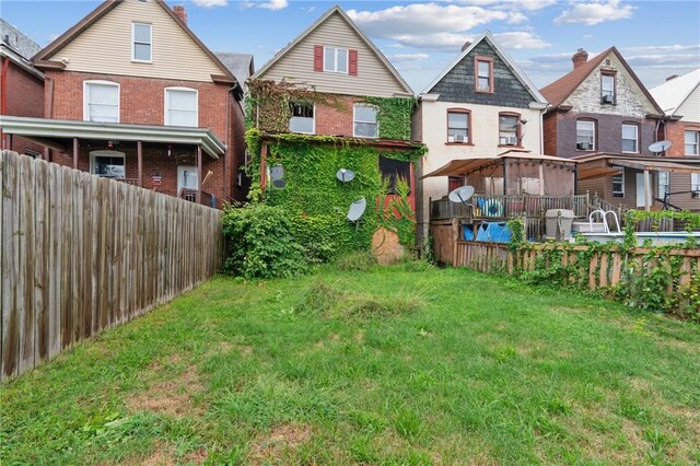 592 E 7th Ave, Tarentum, PA 15084 - rear view of house featuring brick siding, fence, and a lawn