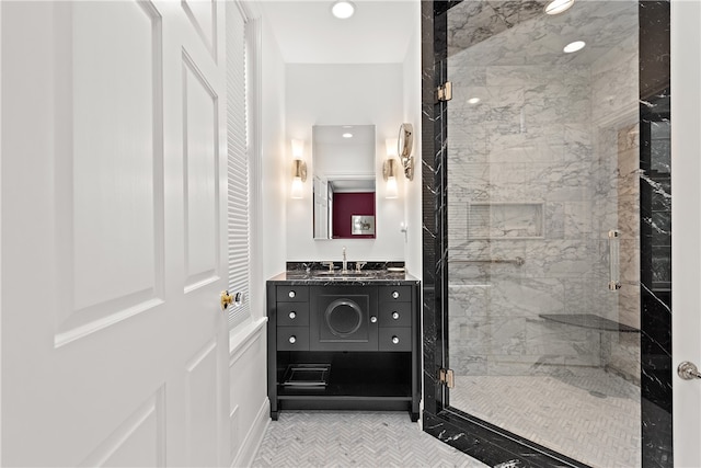 bathroom featuring a shower with shower door, vanity, and tile patterned floors