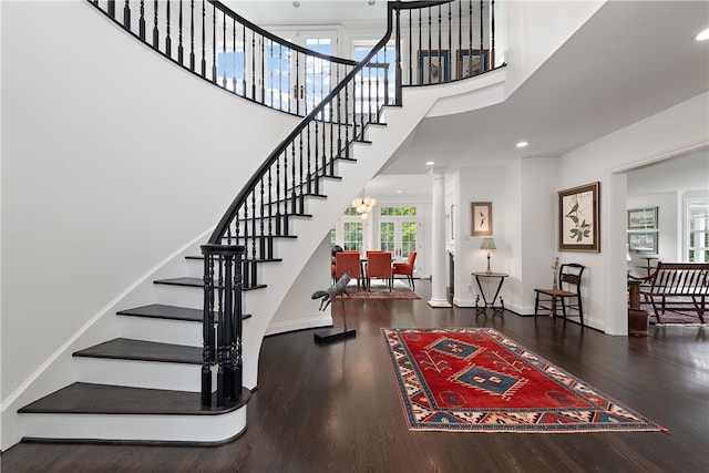 interior space with decorative columns, a high ceiling, and hardwood / wood-style floors