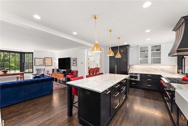 kitchen with a kitchen bar, pendant lighting, backsplash, white cabinetry, and dark hardwood / wood-style flooring