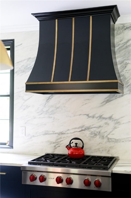 kitchen with ornamental molding and stainless steel gas cooktop