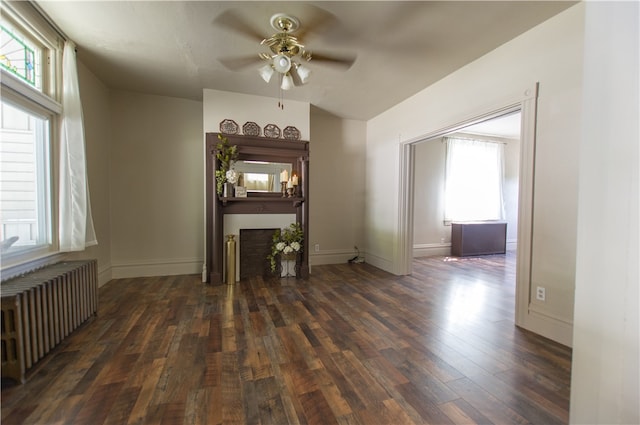 unfurnished living room featuring hardwood / wood-style floors, radiator heating unit, and ceiling fan