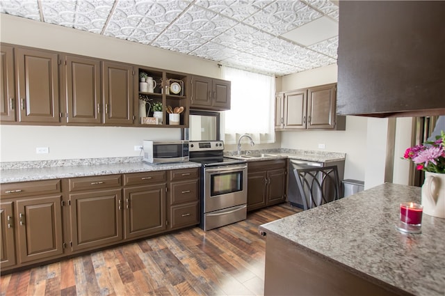 kitchen featuring appliances with stainless steel finishes, dark wood-type flooring, sink, and dark brown cabinets