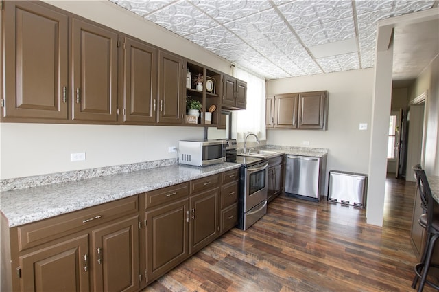 kitchen with sink, stainless steel appliances, and dark hardwood / wood-style flooring