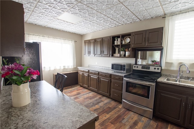 kitchen featuring dark brown cabinets, appliances with stainless steel finishes, dark wood-type flooring, and sink