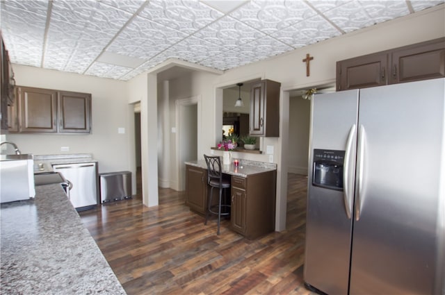 kitchen with appliances with stainless steel finishes, dark hardwood / wood-style floors, and ceiling fan