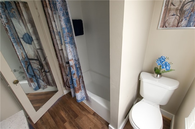 bathroom with shower / bath combo, wood-type flooring, and toilet