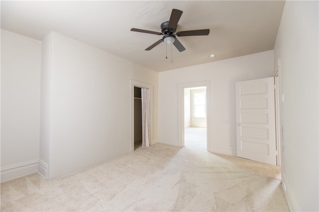 empty room featuring ceiling fan and light colored carpet