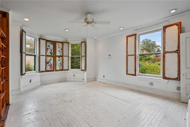 empty room featuring ceiling fan, ornamental molding, and light hardwood / wood-style floors