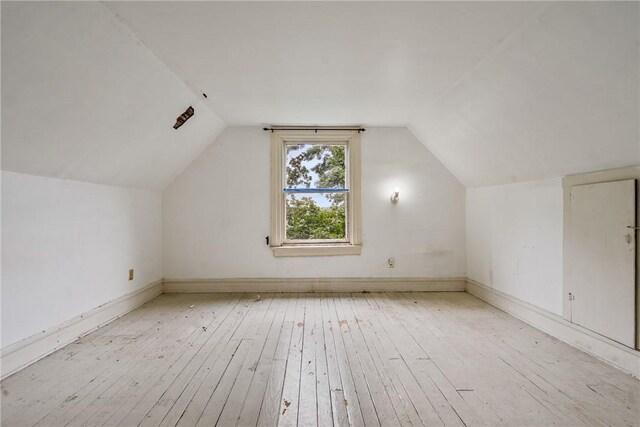 additional living space featuring light hardwood / wood-style flooring and lofted ceiling