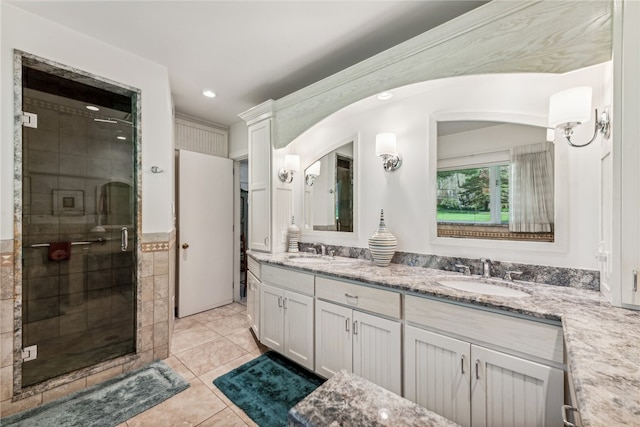 bathroom featuring double sink vanity, a shower with shower door, and tile patterned floors