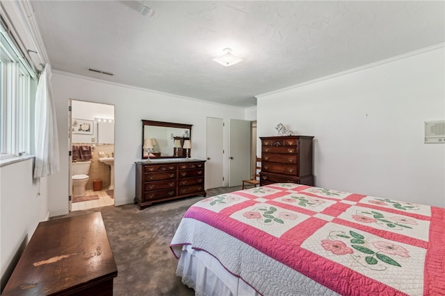 carpeted bedroom featuring ensuite bathroom and ornamental molding