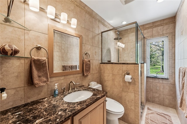 bathroom with tasteful backsplash, tile walls, vanity, and toilet