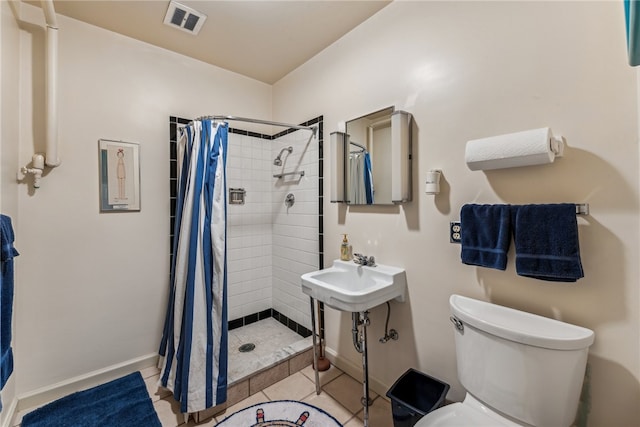 bathroom featuring tile patterned floors, sink, toilet, and curtained shower