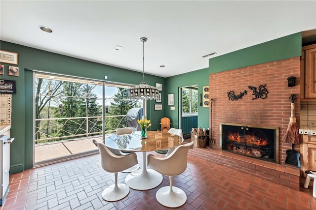 dining room with a notable chandelier and a fireplace