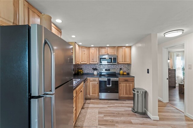 kitchen with tasteful backsplash, appliances with stainless steel finishes, light hardwood / wood-style floors, and light brown cabinets