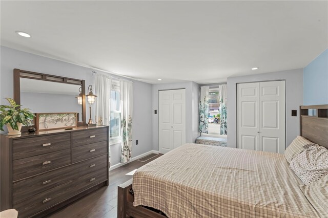 bedroom with dark hardwood / wood-style flooring and two closets