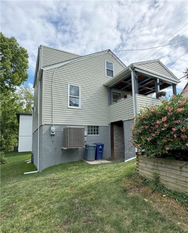 back of property with a lawn and central air condition unit