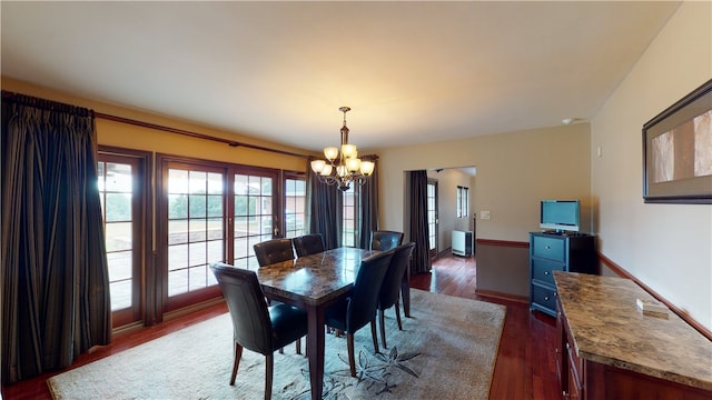 dining space with radiator heating unit, dark hardwood / wood-style floors, and an inviting chandelier