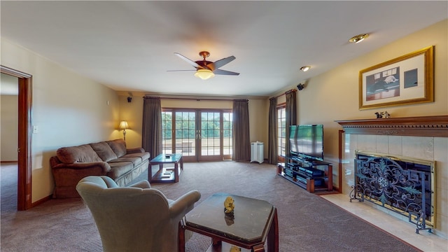 living room with ceiling fan, a fireplace, light colored carpet, and french doors