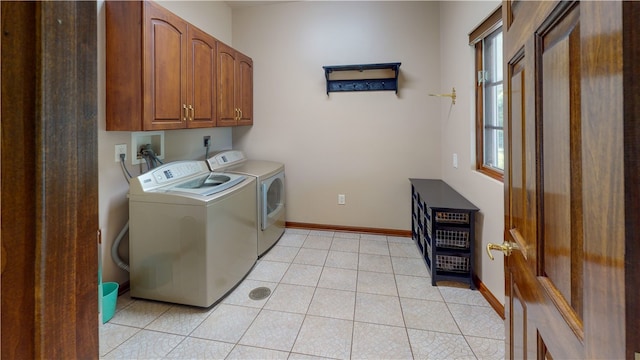 laundry room with independent washer and dryer, light tile patterned flooring, and cabinets