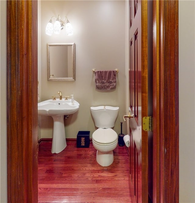 bathroom with hardwood / wood-style floors, sink, and toilet