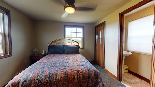 carpeted bedroom with ceiling fan and ensuite bathroom