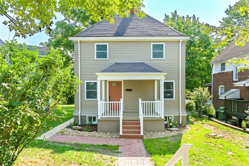 front facade featuring a porch and a front lawn