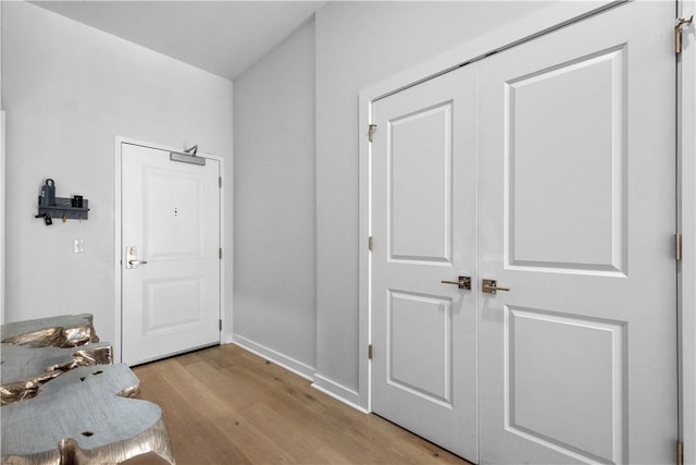 hallway with light wood-type flooring and baseboards