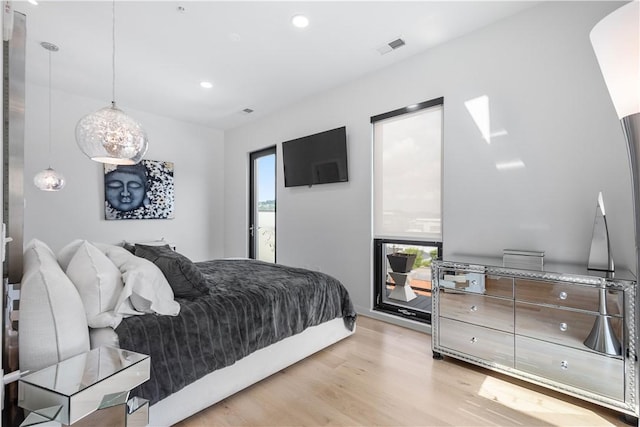 bedroom with light wood finished floors and recessed lighting